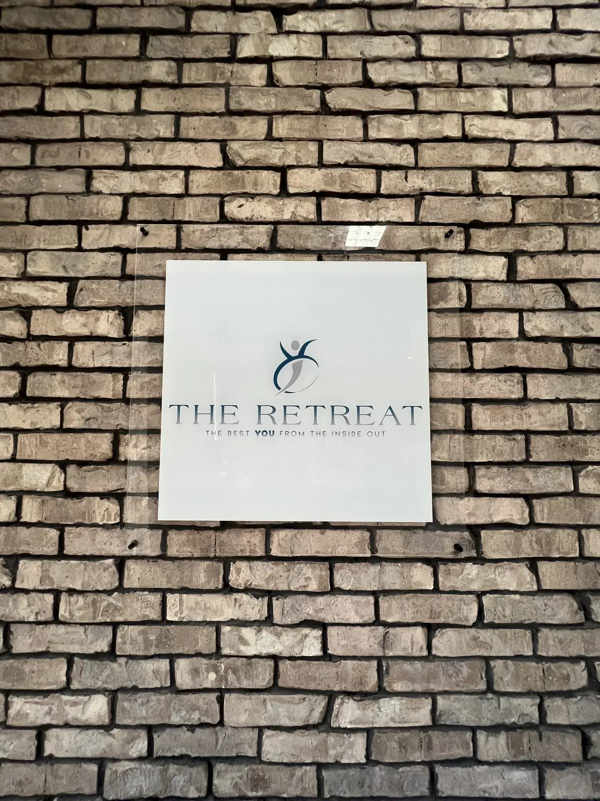 The Retreat's sign mounted on the brick exterior of the Elko studio.