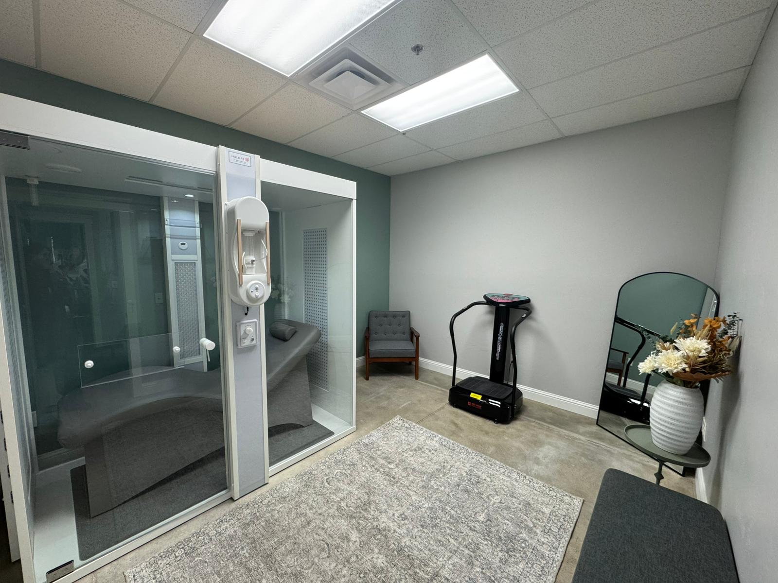 The halotherapy sauna room at The Retreat, with the glass cabin and treatment lounger.