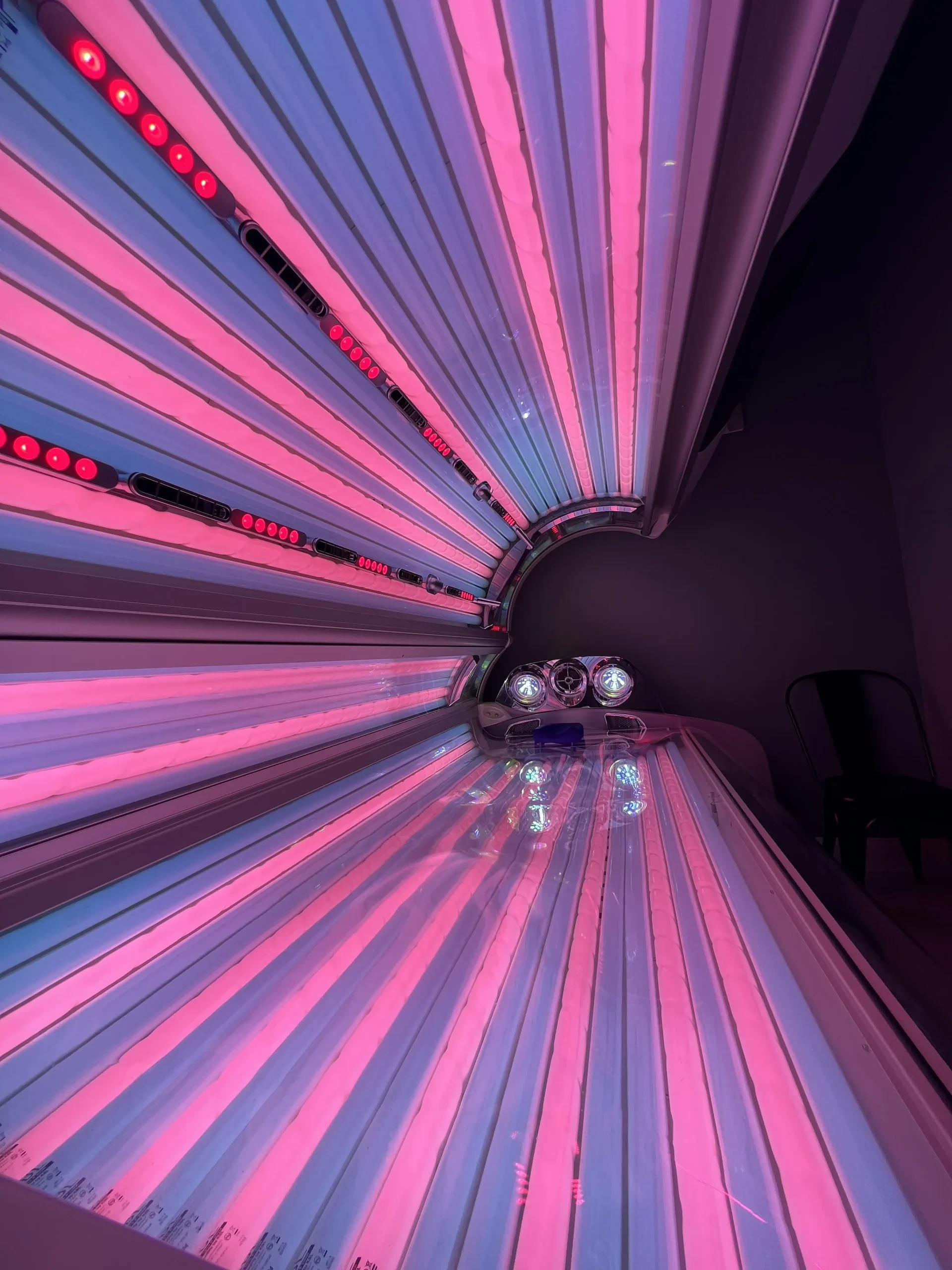 Inside The Retreat's hybrid tanning bed, lit in red and blue light.